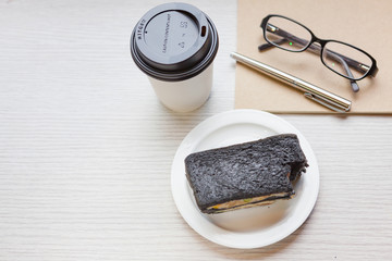 A coffee cup with charcoal sanwiches