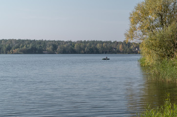 Fototapeta na wymiar Beautiful fall lake with a fishing boat
