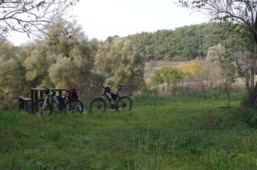 Camping mountain bikes standing near table in forest