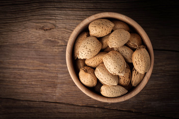 Almonds in-shell in wooden bowl.