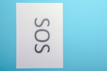 Word SOS written on paper