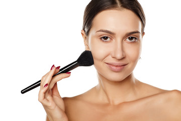 Fototapeta premium young woman apply makeup base on her face