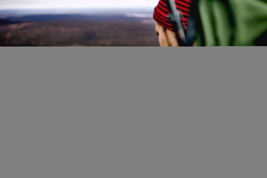 Hiker checking compass on cliff top, Keimiotunturi, Lapland, Finland