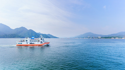 Ferry crossing the inland sea between Miyajimaguchi and Miyajima island , destination tItsukushima shrine , Hiroshima , Japan