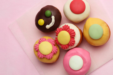 Small Cupcake Flower topping and Chocolate candy smile cupcake group and silver fork on sweet pink background