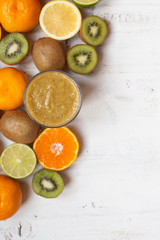 Smoothie rich in vitamin C made with oranges, lemons, limes, clementines, kiwis, top view, selective focus