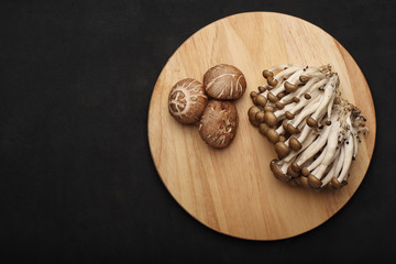 Shiitake mushrooms on wood block and the mushroom in sack on black background