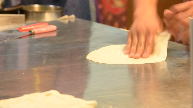 A woman used oil to help flatten roti dough bread, Texture background
 