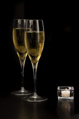 Calici di champagne con candela su fondo nero