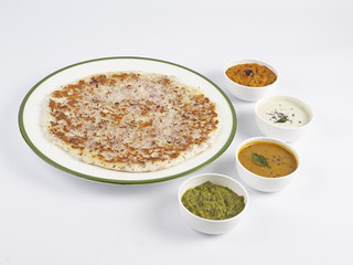 DOSAI WITH SAMBAR AND 3 TYPE OF CHUTNEY SERVED IN A WHITE PLATE ON WHITE BACKGROUND