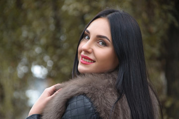 Attractive girl with a smile in fur waistcoat