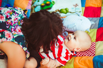 lovely and cute little baby with mommy lying on colorful carpet