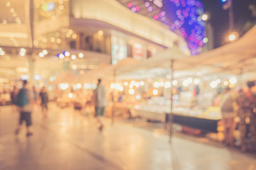 Blurred image people shopping at night time with retro color effected
