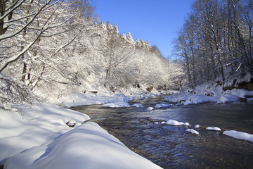River bend in winter forest with a lot of snow