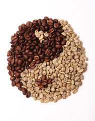 Roasted and green coffee beans in shape yin yang on white background
