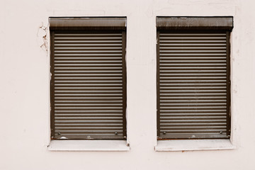 Wall with two closed by roller-blind windows
