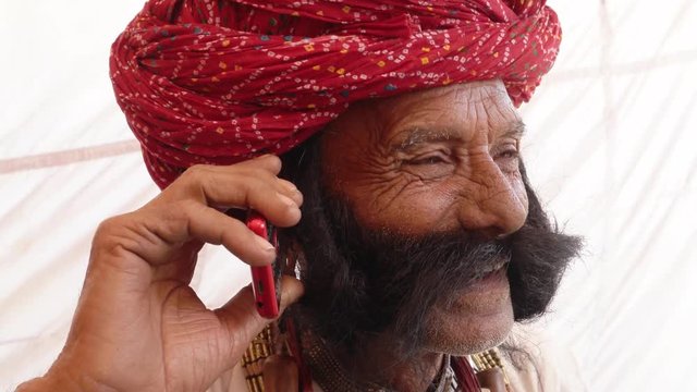 Hand-held Rajasthani elderly male on a smart cell phone mobile conversation