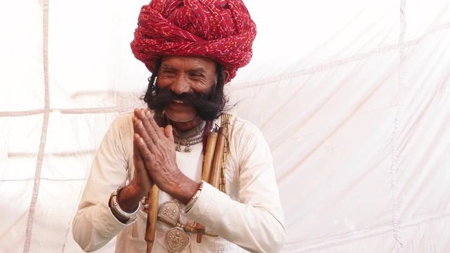 Smiling man from Rajasthan with big moustache and hands joined in namaste welcoming guests 