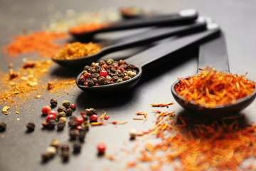 Different spices in spoons on table