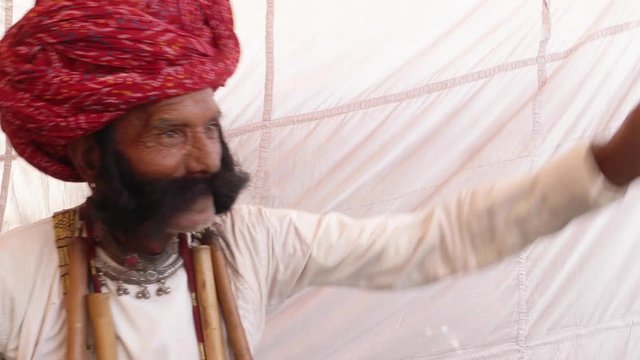 Angry man from Rajasthan with big moustache calling out someone in anger and raising hands