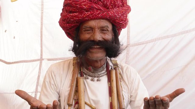 Smiling man from Rajasthan with big moustache and hands joined in namaste welcoming guests 