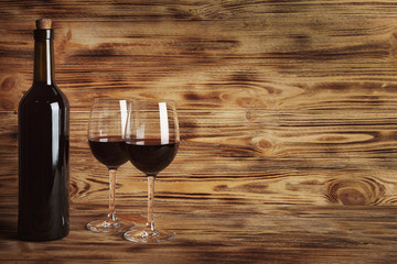 Wine bottle and glasses on wooden background