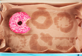 Delicious donut on greasy paper in box