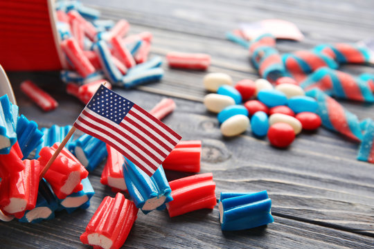 USA flag with delicious candies on blue wooden background