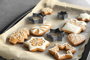 Delicious Christmas cookies with cutters on baking tray