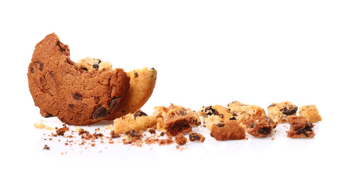 Tasty cookies with chocolate chips and crumbs on white background