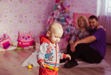 Fototapeta premium little boy playing near xmas tree