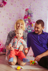 Naklejka premium mother, father and little boy on the background of the Christmas