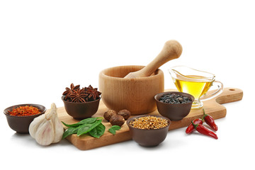 Composition with different spices and mortar on white background