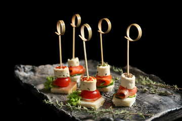 Delicious canapes on black background