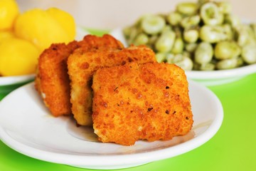 Fried fish fillet, fava bean, potato.