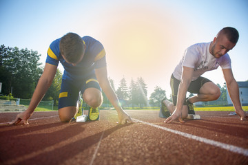 Close-up side view of cropped people ready to race on track field
