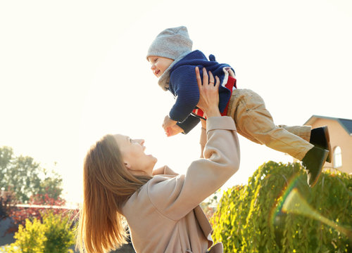 Young Woman Holding Cute Little Baby Outdoors