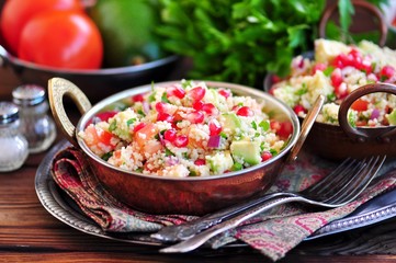Healthy salad with couscous, tomato, avocado, red onion, pomegranate and olive oil. Eastern cuisine.