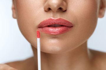 Beauty Makeup. Beautiful Woman Applies Lip Gloss
