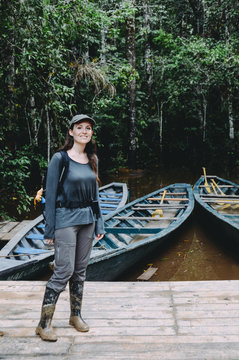 Peru, Tambopata, Woman with muddy rubber boots standing on jetty at Amazon river