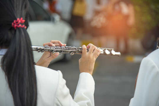 Musician playing flute on footpath, Marching Band