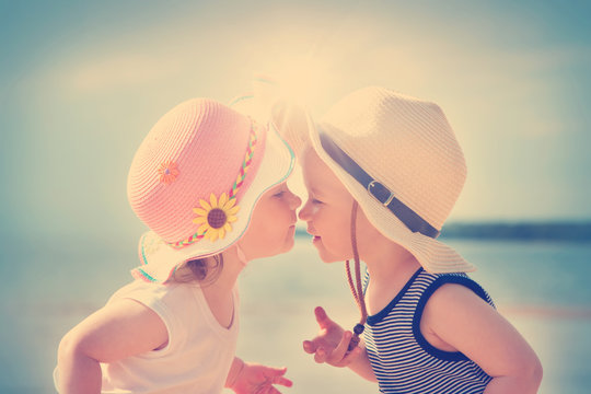 Babygirl and babyboy kissing on the beach