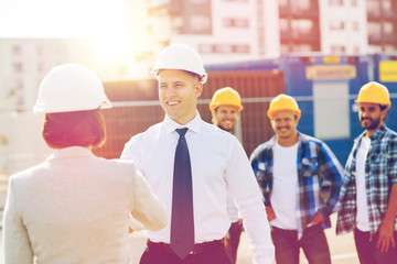 group of smiling builders in hardhats outdoors