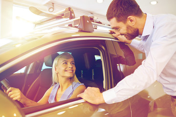 happy couple buying car in auto show or salon