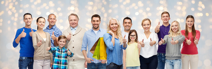 happy people with shopping bags showing thumbs up