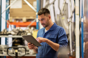 auto mechanic or smith with tablet pc at workshop