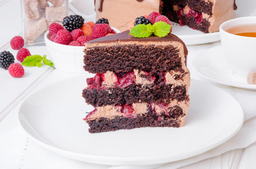 Chocolate layer cake with cherry filling and fresh berries on top