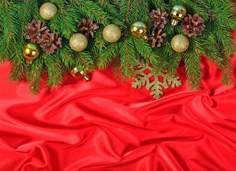 Golden Christmas decorations and spruce branch and cones on a re