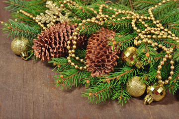 Golden Christmas decorations and spruce branch and cones