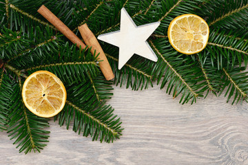 Zimtstangen, Orangescheiben und Stern auf Tannenzweige
